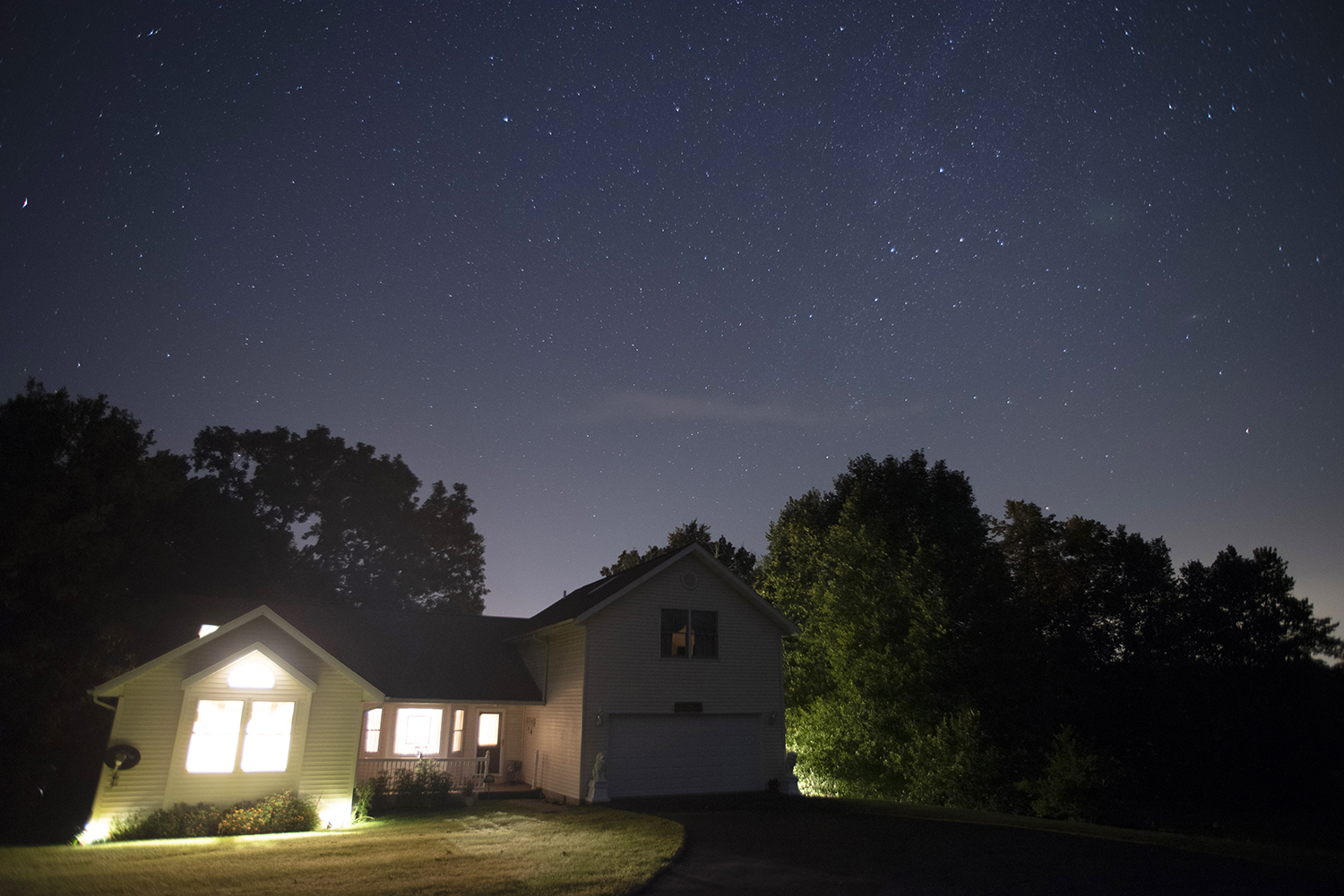 A few hours northwest of Chicago, stars are visible in the early night in Lake Carroll, Illinois, on a comfortable summer night in Aug. 2018.